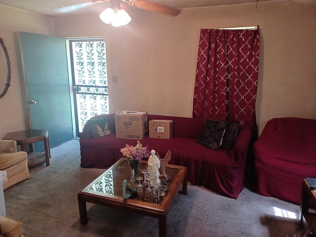 living room featuring carpet, plenty of natural light, ceiling fan, and a textured ceiling