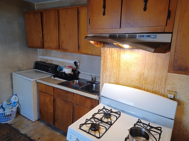 kitchen with washer / clothes dryer, gas range gas stove, sink, and extractor fan