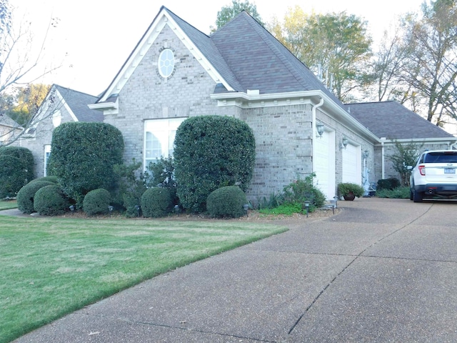 view of side of home featuring a garage and a yard