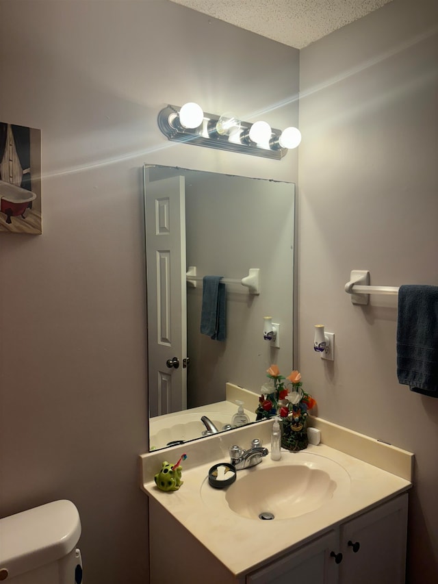 bathroom featuring vanity, toilet, and a textured ceiling