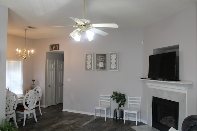 living room featuring a fireplace, ceiling fan with notable chandelier, and dark hardwood / wood-style floors