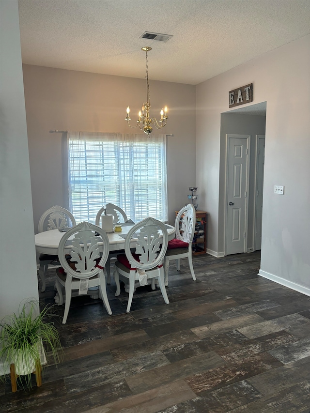 dining area with a textured ceiling, dark hardwood / wood-style floors, and a notable chandelier