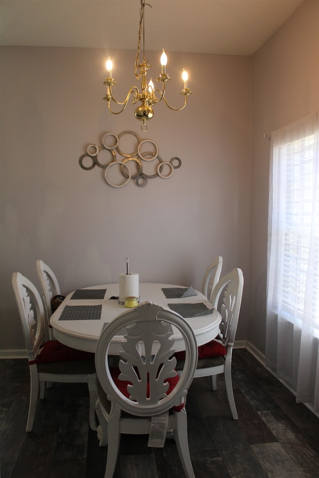 dining room with dark hardwood / wood-style flooring and an inviting chandelier