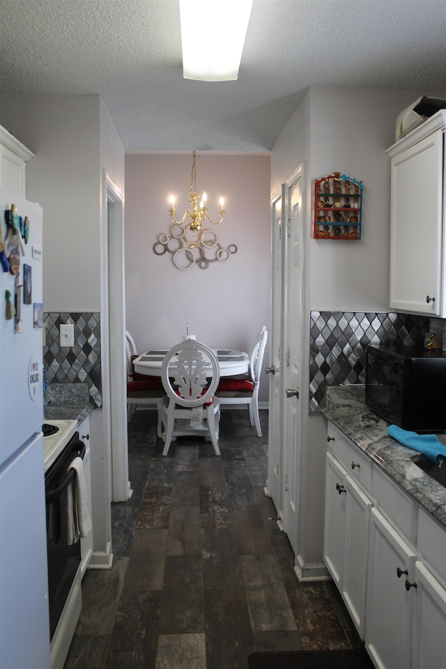 kitchen with an inviting chandelier, white cabinetry, hanging light fixtures, and black appliances