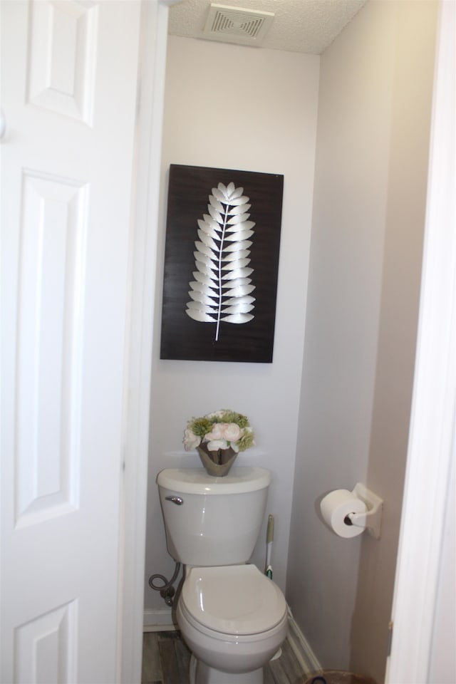 bathroom featuring a textured ceiling and toilet