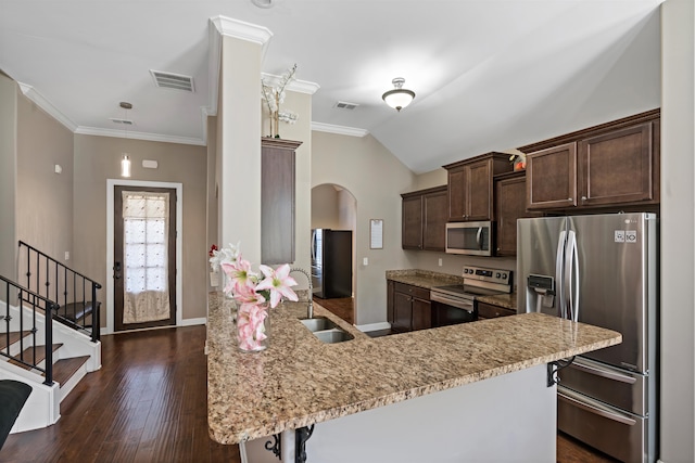 kitchen with a kitchen breakfast bar, sink, appliances with stainless steel finishes, dark hardwood / wood-style flooring, and kitchen peninsula