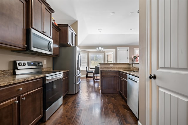 kitchen with sink, hanging light fixtures, dark wood-type flooring, a notable chandelier, and appliances with stainless steel finishes