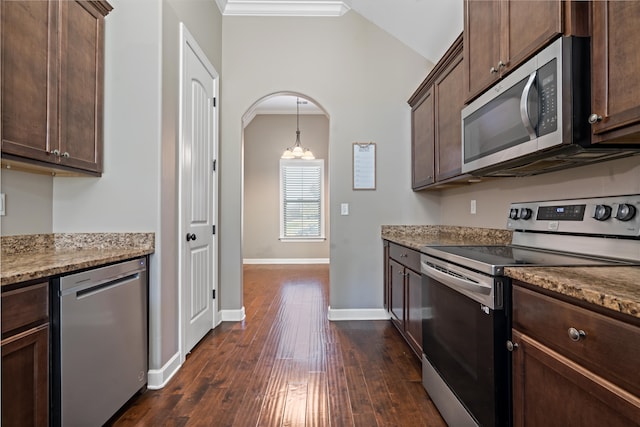 kitchen featuring light stone countertops, dark hardwood / wood-style floors, dark brown cabinets, appliances with stainless steel finishes, and ornamental molding