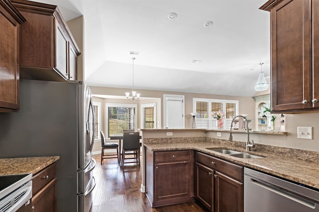 kitchen with sink, dark wood-type flooring, pendant lighting, vaulted ceiling, and appliances with stainless steel finishes