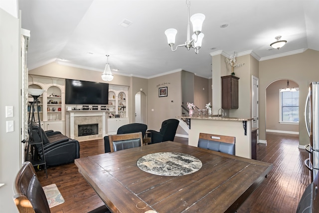 dining room featuring dark hardwood / wood-style flooring, crown molding, and vaulted ceiling