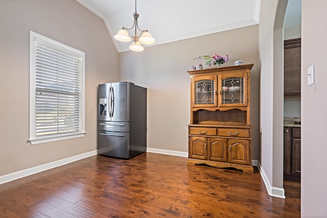 kitchen with dark hardwood / wood-style flooring, ornamental molding, vaulted ceiling, a notable chandelier, and stainless steel fridge with ice dispenser