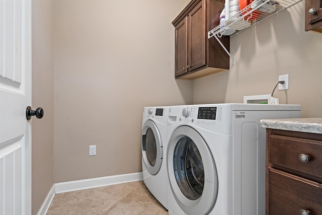 washroom featuring washer and clothes dryer, light tile patterned floors, and cabinets