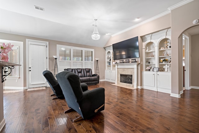 living room with dark hardwood / wood-style floors, built in features, lofted ceiling, and a premium fireplace