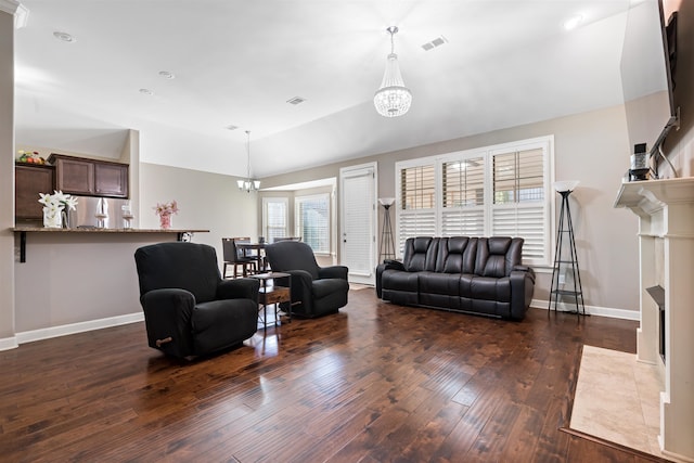 living room with dark hardwood / wood-style floors, lofted ceiling, and a chandelier