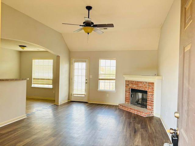 unfurnished living room featuring dark hardwood / wood-style floors, ceiling fan, lofted ceiling, and a fireplace