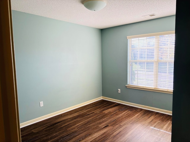 empty room with a textured ceiling and hardwood / wood-style flooring