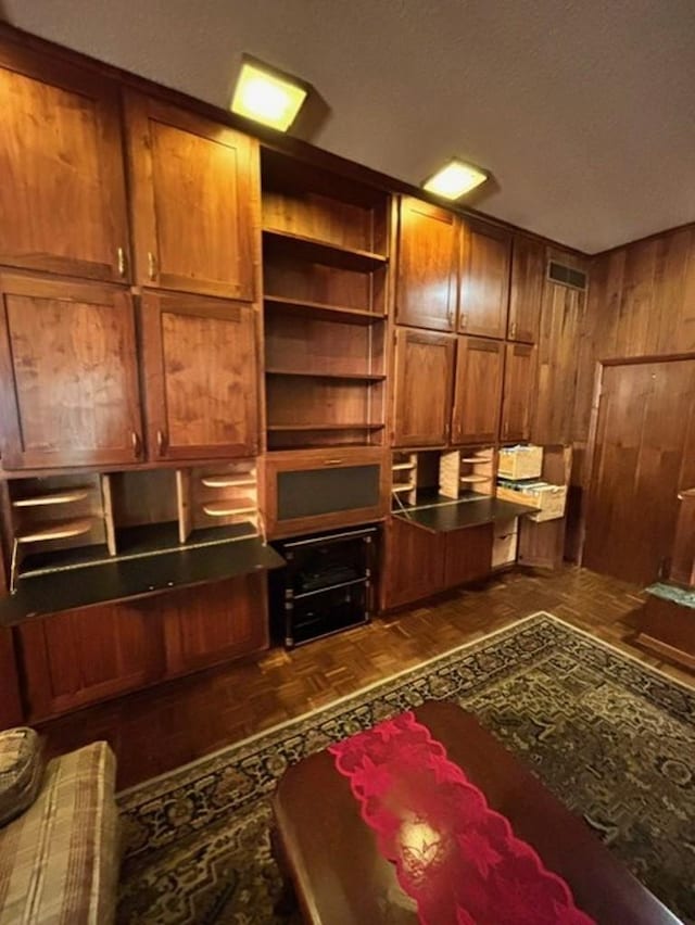 home office with wood walls and dark parquet flooring