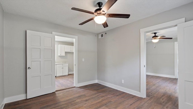 spare room featuring a textured ceiling, ceiling fan, and dark hardwood / wood-style floors