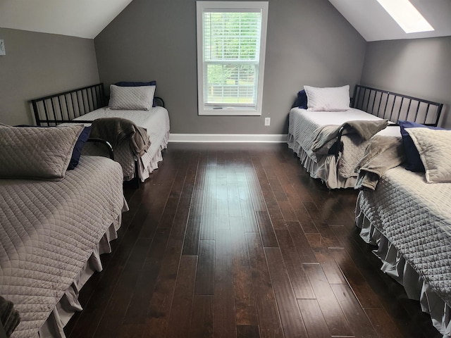 bedroom featuring lofted ceiling with skylight and dark wood-type flooring