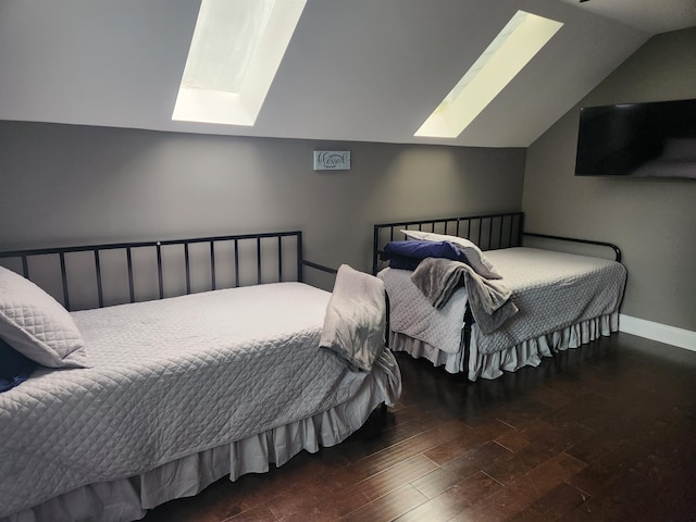 bedroom with dark hardwood / wood-style floors and vaulted ceiling with skylight