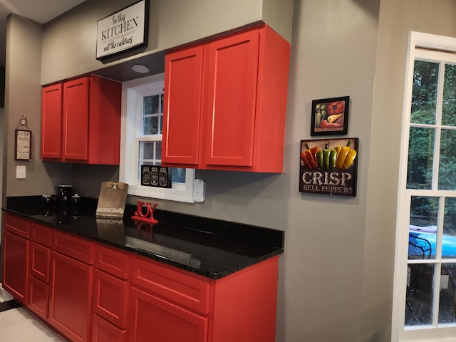 kitchen featuring plenty of natural light and dark stone counters