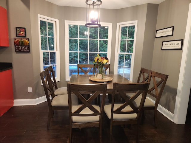 dining area with a healthy amount of sunlight, dark hardwood / wood-style flooring, and a chandelier