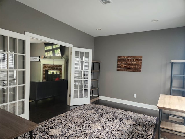 office space featuring french doors, a fireplace, and dark hardwood / wood-style floors