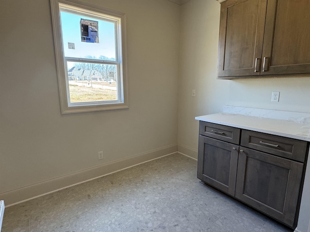 interior space featuring light floors and baseboards