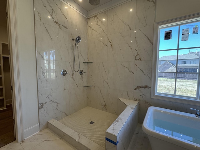 bathroom featuring marble finish floor, a freestanding tub, and a marble finish shower