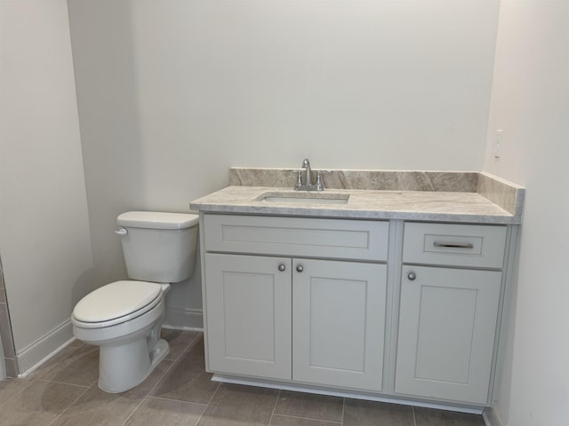 bathroom featuring vanity, toilet, and baseboards