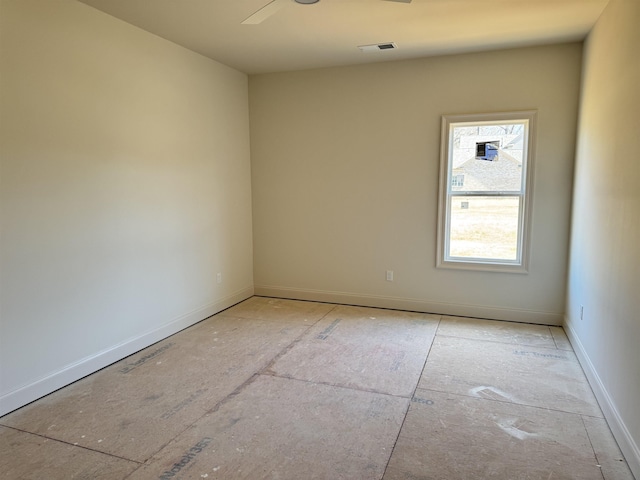 empty room featuring ceiling fan, visible vents, and baseboards