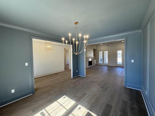 unfurnished dining area featuring dark wood-style floors, a fireplace, baseboards, and ornamental molding