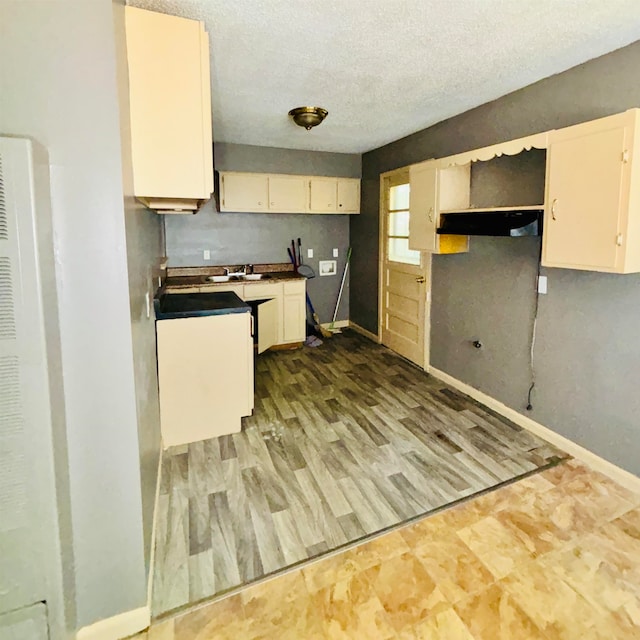 kitchen with a textured ceiling and light hardwood / wood-style flooring