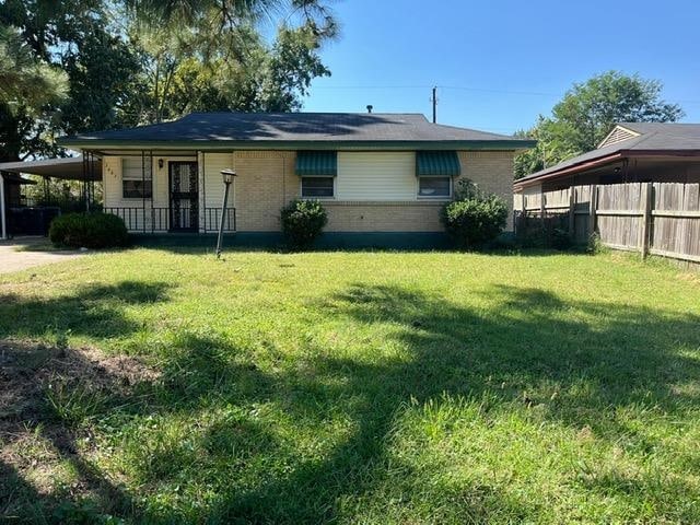 view of front of property with a front yard and a carport