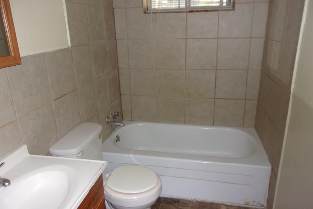 full bathroom featuring vanity, toilet, tile walls, and tiled shower / bath combo