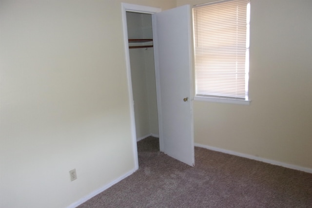 unfurnished bedroom featuring carpet floors and a closet