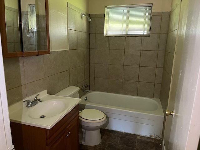 full bathroom with vanity, tile patterned flooring, tiled shower / bath combo, toilet, and tile walls