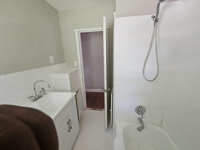 bathroom with tile patterned floors, tiled shower / bath combo, and sink