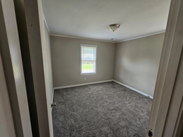 empty room featuring crown molding and dark colored carpet