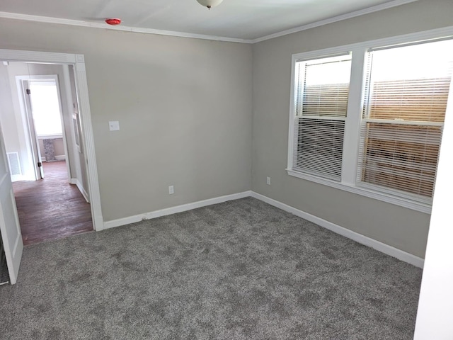 spare room with dark colored carpet and crown molding