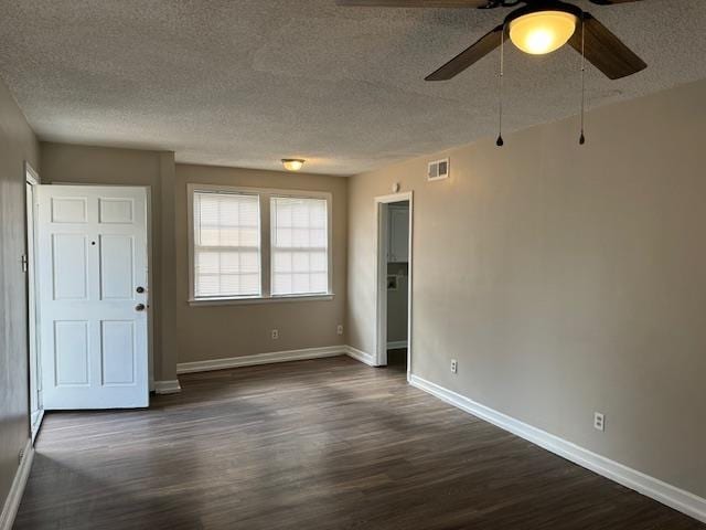 unfurnished room featuring a textured ceiling, ceiling fan, and dark wood-type flooring