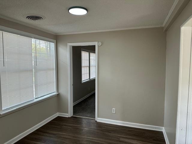 unfurnished room featuring a wealth of natural light, dark hardwood / wood-style floors, and ornamental molding