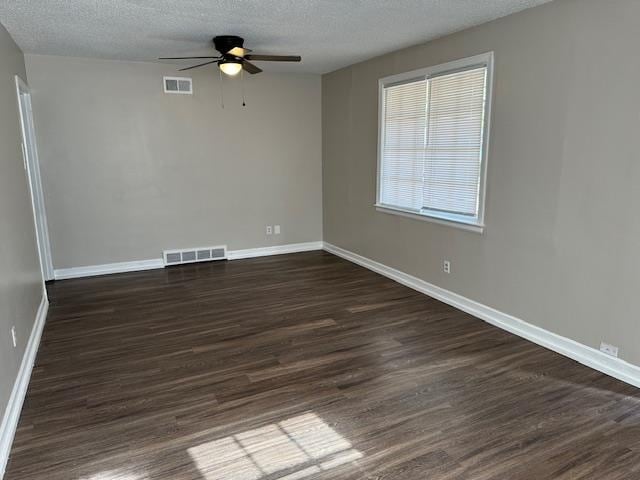 empty room with ceiling fan, dark hardwood / wood-style flooring, and a textured ceiling