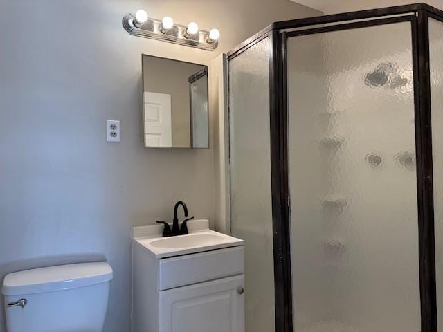 bathroom with vanity, an enclosed shower, and toilet