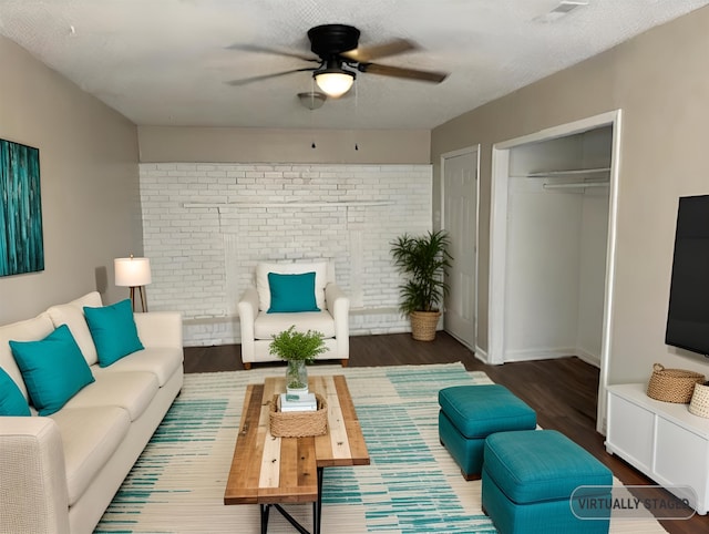 living room featuring a textured ceiling, dark hardwood / wood-style flooring, and ceiling fan