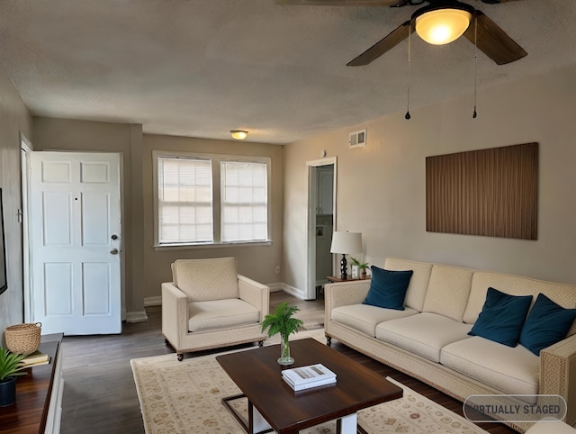 living room featuring dark hardwood / wood-style floors, ceiling fan, and a textured ceiling