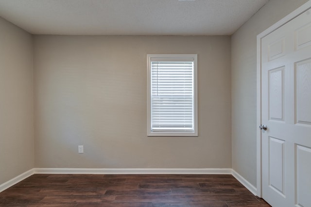 spare room with dark hardwood / wood-style flooring and a textured ceiling