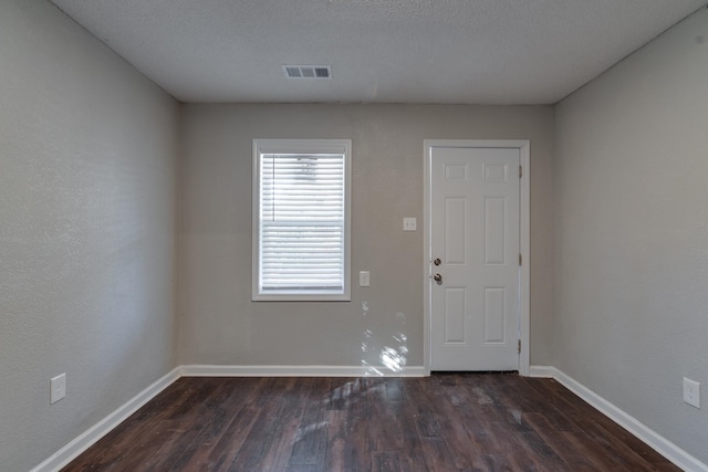 foyer featuring dark hardwood / wood-style flooring and a textured ceiling