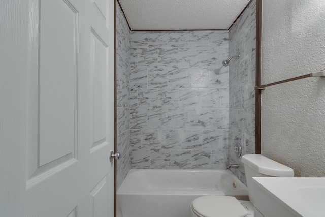 full bathroom with vanity, toilet, a textured ceiling, and tiled shower / bath combo