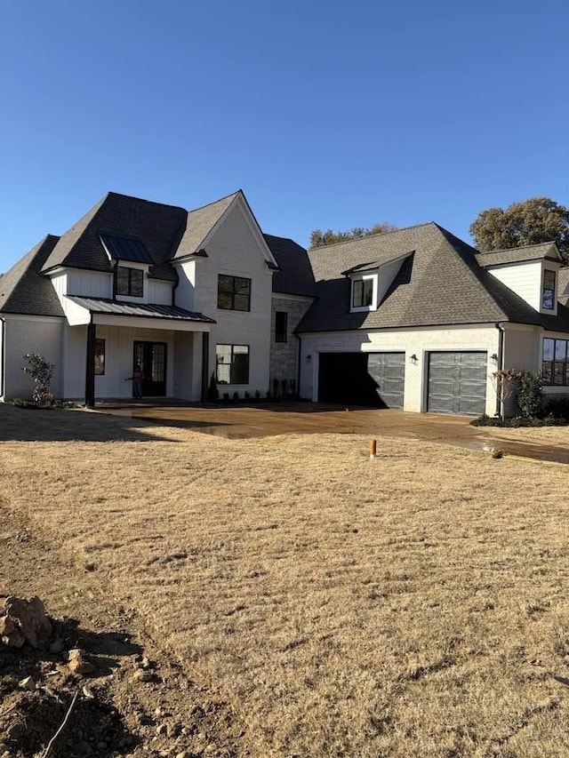 modern farmhouse style home featuring covered porch and a garage